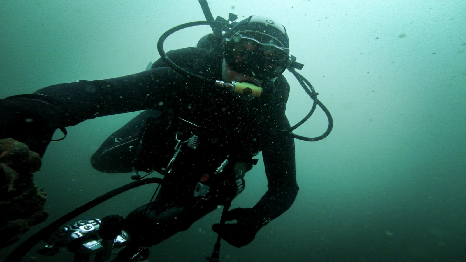 Berufstaucher mit Ausrüstung unter Wasser